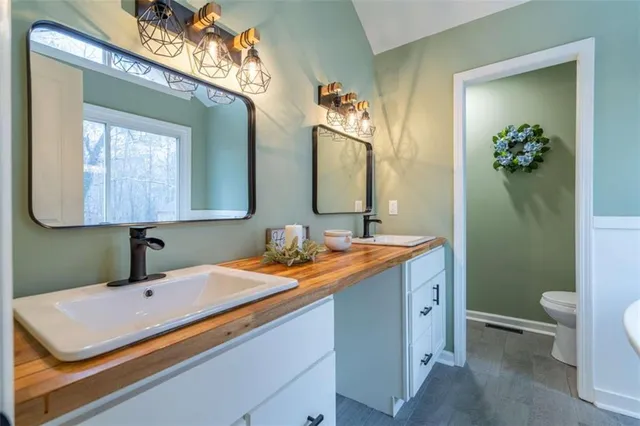 a bathroom with a sink a toilet and mirror