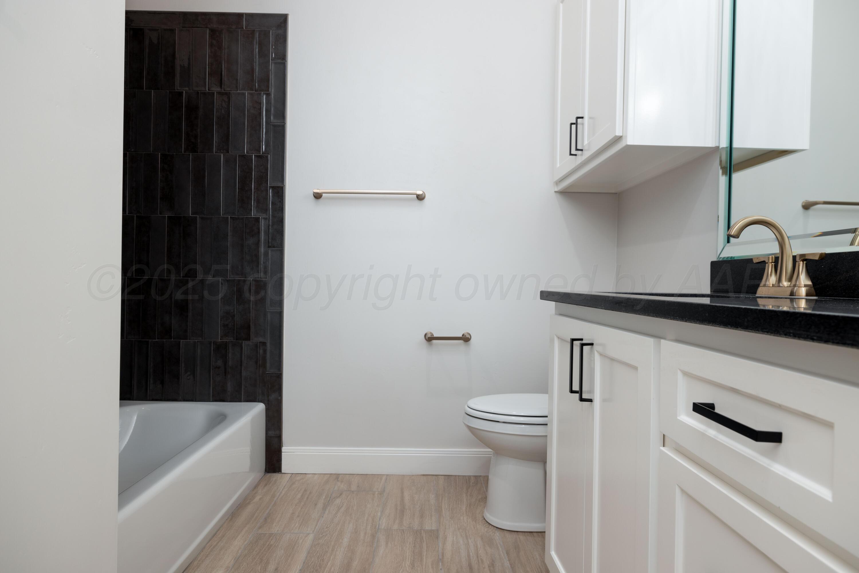 10250 Prickly Pear Road Amarillo, TX 79119 - Photo 18 of 41 a bathroom with a bathtub a sink a toilet and a window