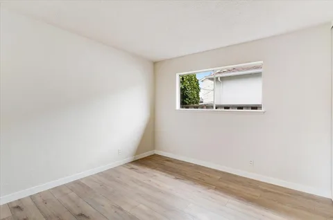 a view of a small space with wooden floor and a window