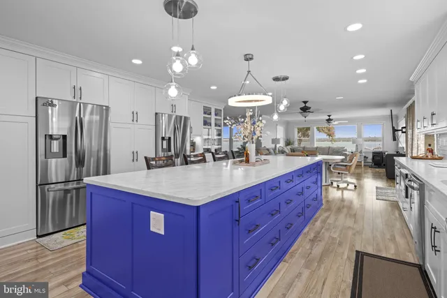 a kitchen with stainless steel appliances kitchen island granite countertop a large center island attached withe living room