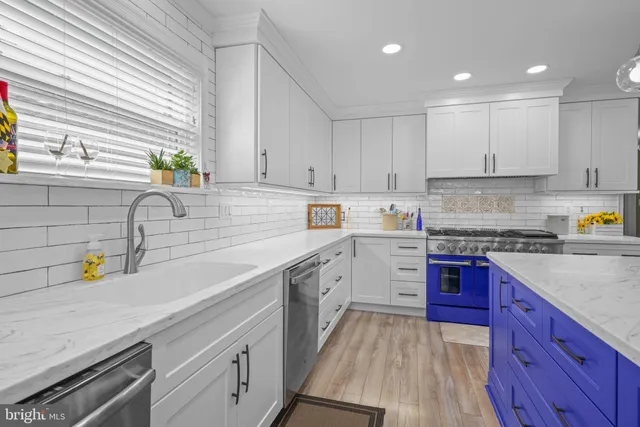 a kitchen with granite countertop a stove and a white cabinets