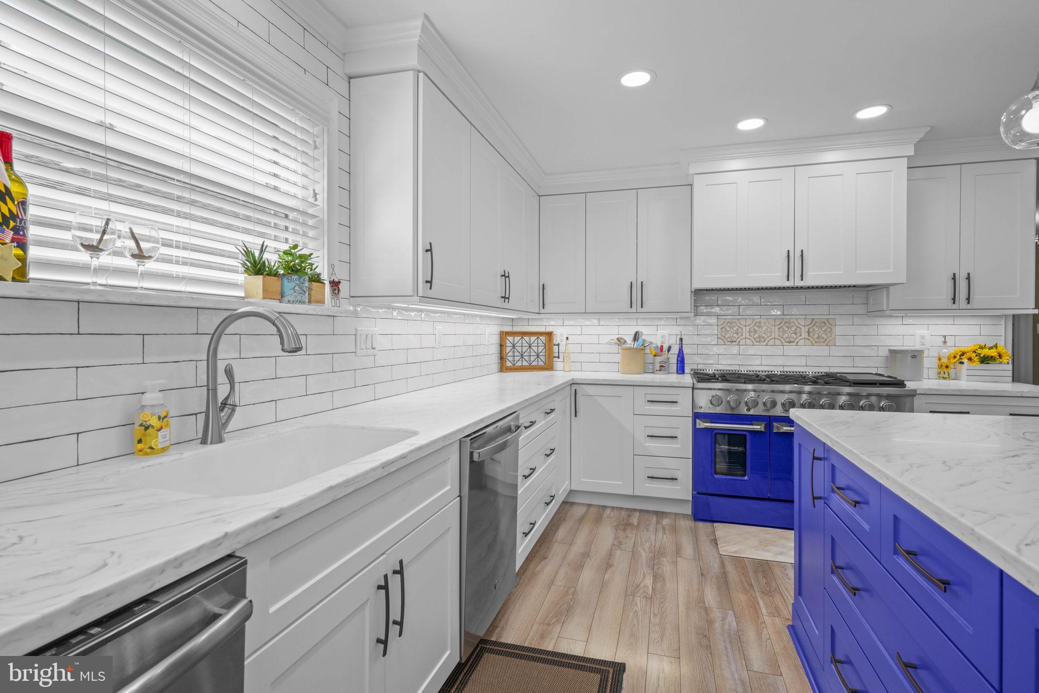 17432 Rock Point Road Newburg, MD 20664 - Photo 10 of 55 a kitchen with a sink dishwasher a stove and white cabinets with wooden floor