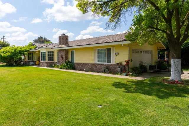 a front view of house with yard and green space