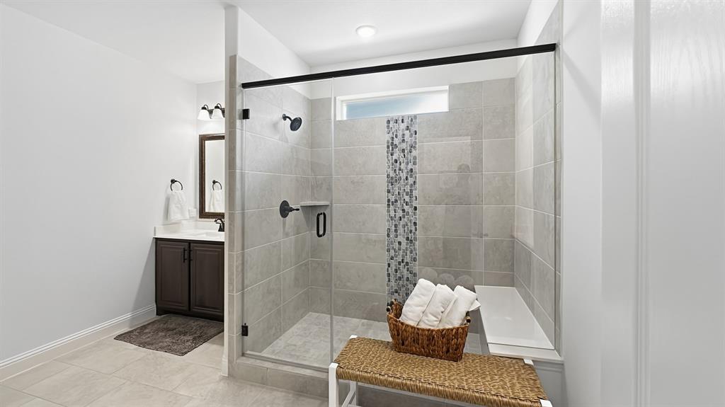 5216 Troupe Road McKinney, TX 75071 - Photo 21 of 40 Walk-in shower with clear glass enclosure, a mosaic tile accent strip, and a built-in bench