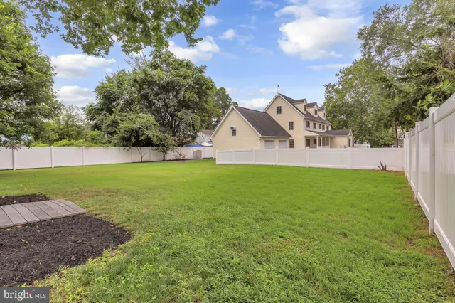 an aerial view of a houses with outdoor space and trees all around