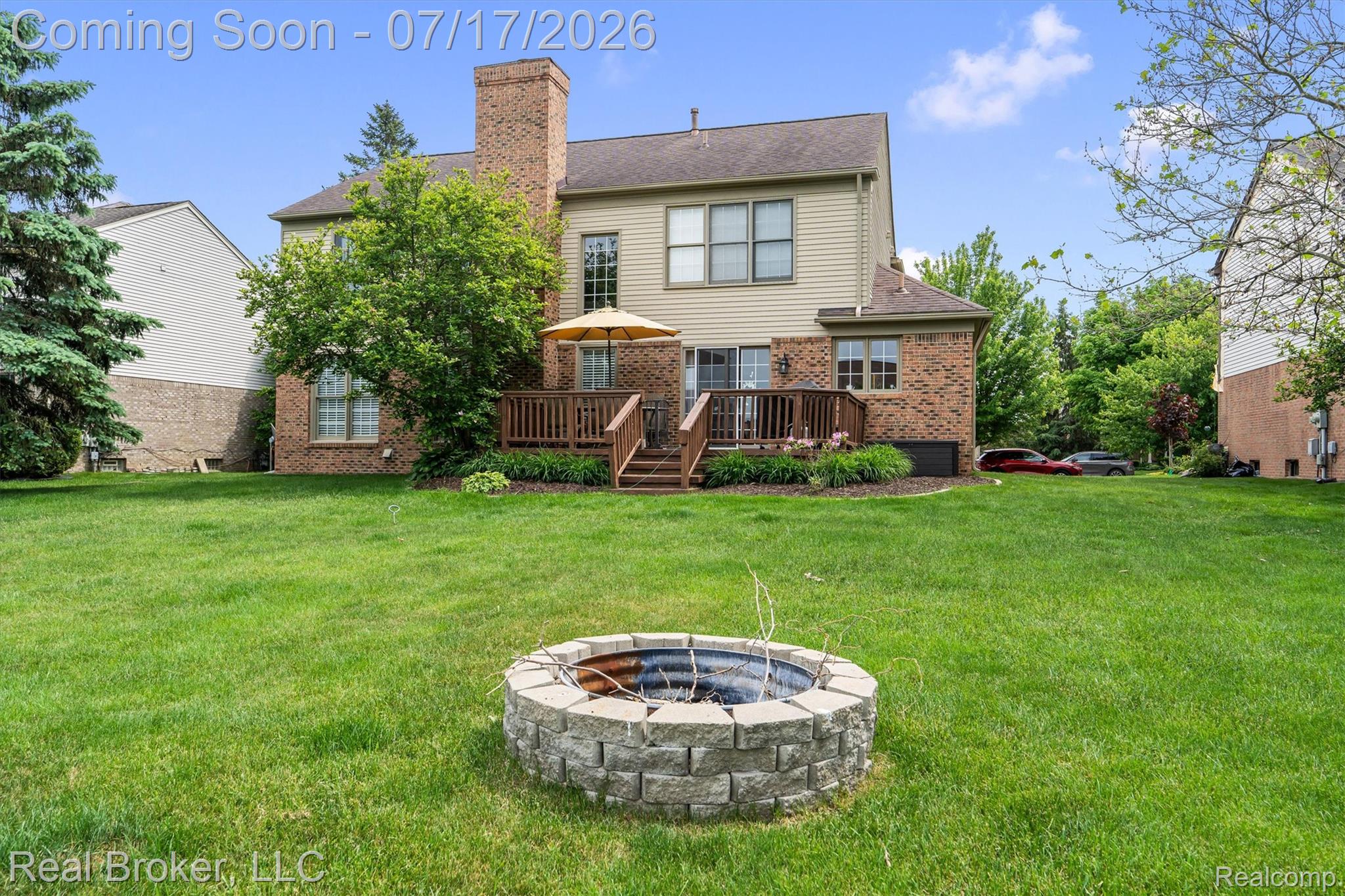 45192 Thornhill Road Canton, MI 48188 - Photo 30 of 34 Spacious backyard featuring a stone-clad fire pit, a multi-level wood deck, and mature landscaping