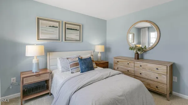 a bedroom with bed a mirror and a window