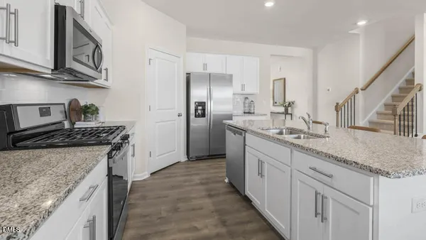 a kitchen with stainless steel appliances granite countertop a sink stove and refrigerator