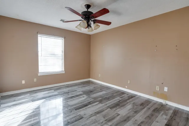 wooden floor in an empty room with a window