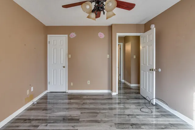 a view of a hallway with wooden floor and staircase