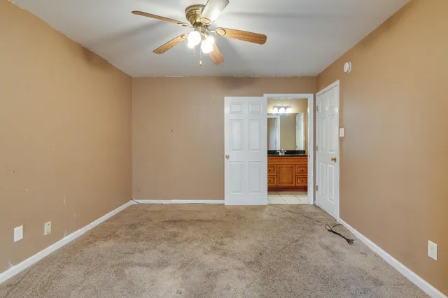 an empty room with fan and entrance