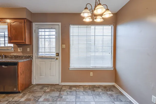 an empty room with wooden floor mirror and windows