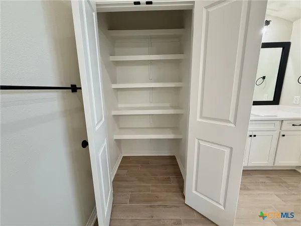 a view of walk in closet with empty racks