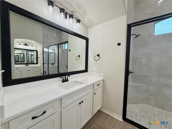 a bathroom with a double vanity sink and a mirror