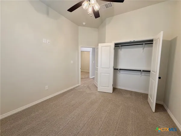 a view of an empty room with a kitchen