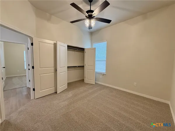 an empty room with closet and windows
