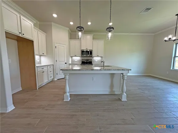 a kitchen with kitchen island a sink stainless steel appliances and cabinets