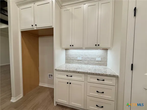 a kitchen with granite countertop white cabinets and sink