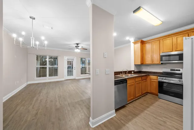 a kitchen with stainless steel appliances granite countertop a stove and a wooden floors