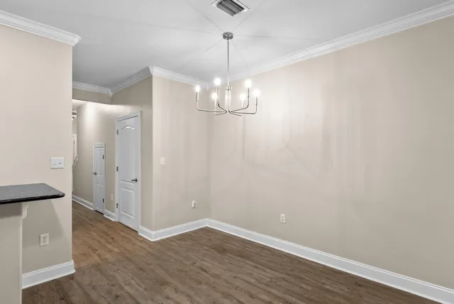 a view of a room with wooden floor and white walls