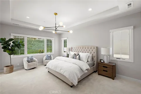 a spacious bedroom with a bed and a chandelier