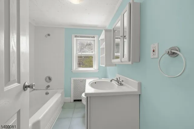 a bathroom with a tub a sink and mirror