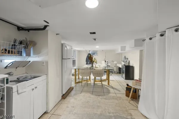 a view of a kitchen with fridge and workspace