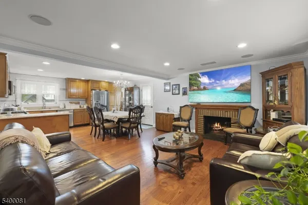 a living room with fireplace furniture and a dining table with kitchen view