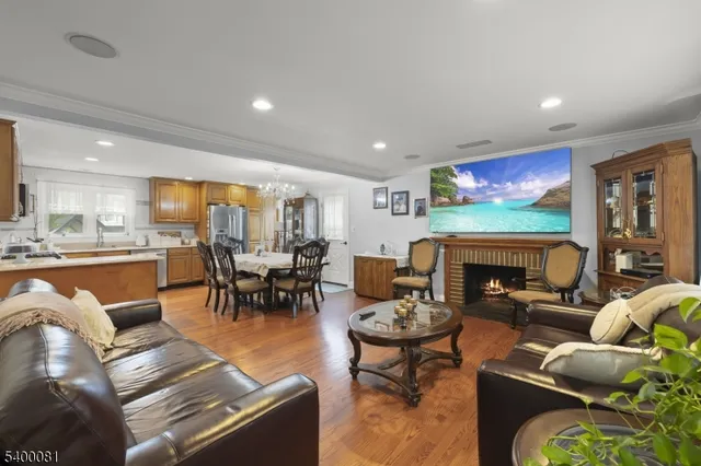 a living room with fireplace furniture and a dining table with kitchen view