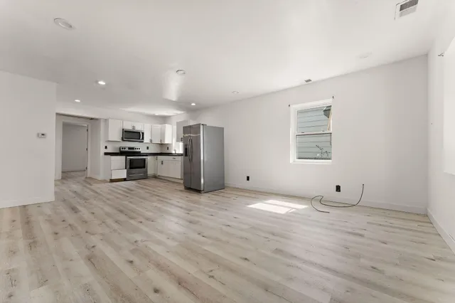 a view of a kitchen with a sink and a refrigerator