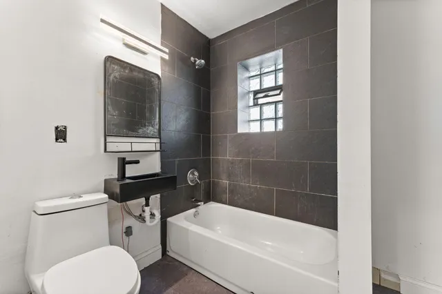 a white toilet sitting next to a bathtub