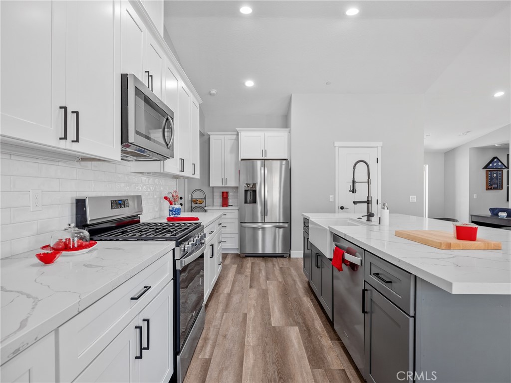 24162 Shoshone Road Apple Valley, CA 92307 - Photo 9 of 40 a kitchen that has a lot of cabinets and wooden floor