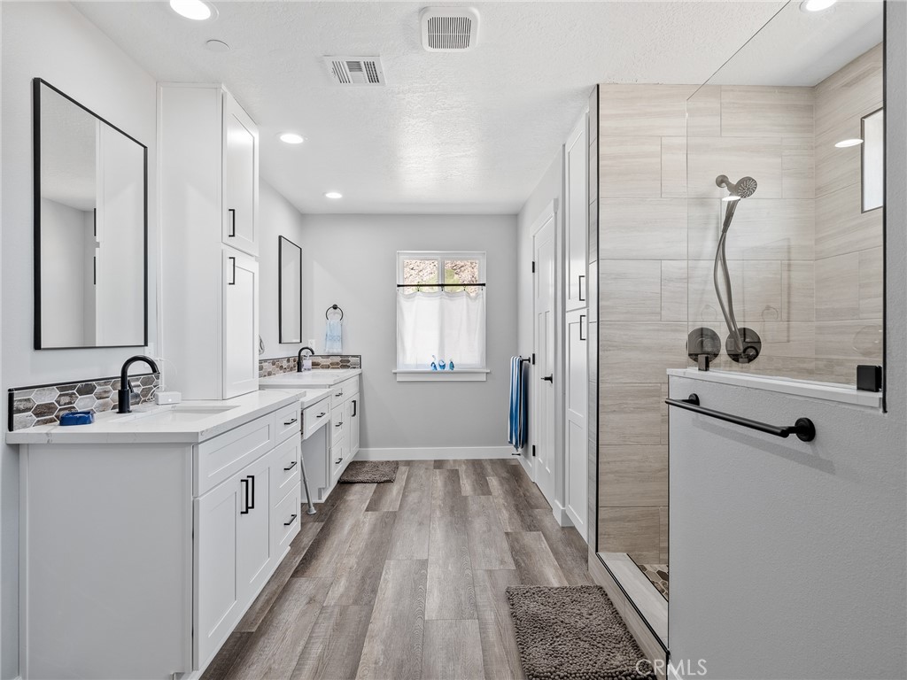 24162 Shoshone Road Apple Valley, CA 92307 - Photo 14 of 40 a bathroom with a double vanity sink a mirror and a shower