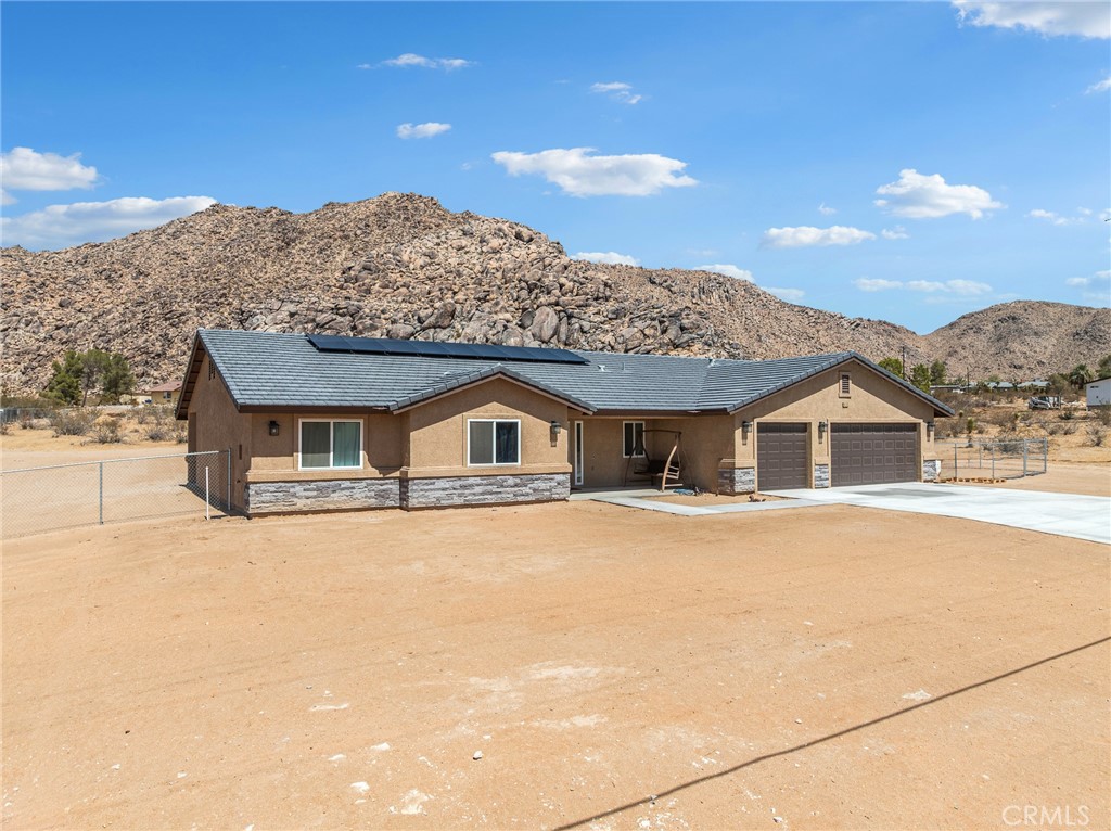 24162 Shoshone Road Apple Valley, CA 92307 - Photo 2 of 40 a front view of a house with a yard and mountain view in back