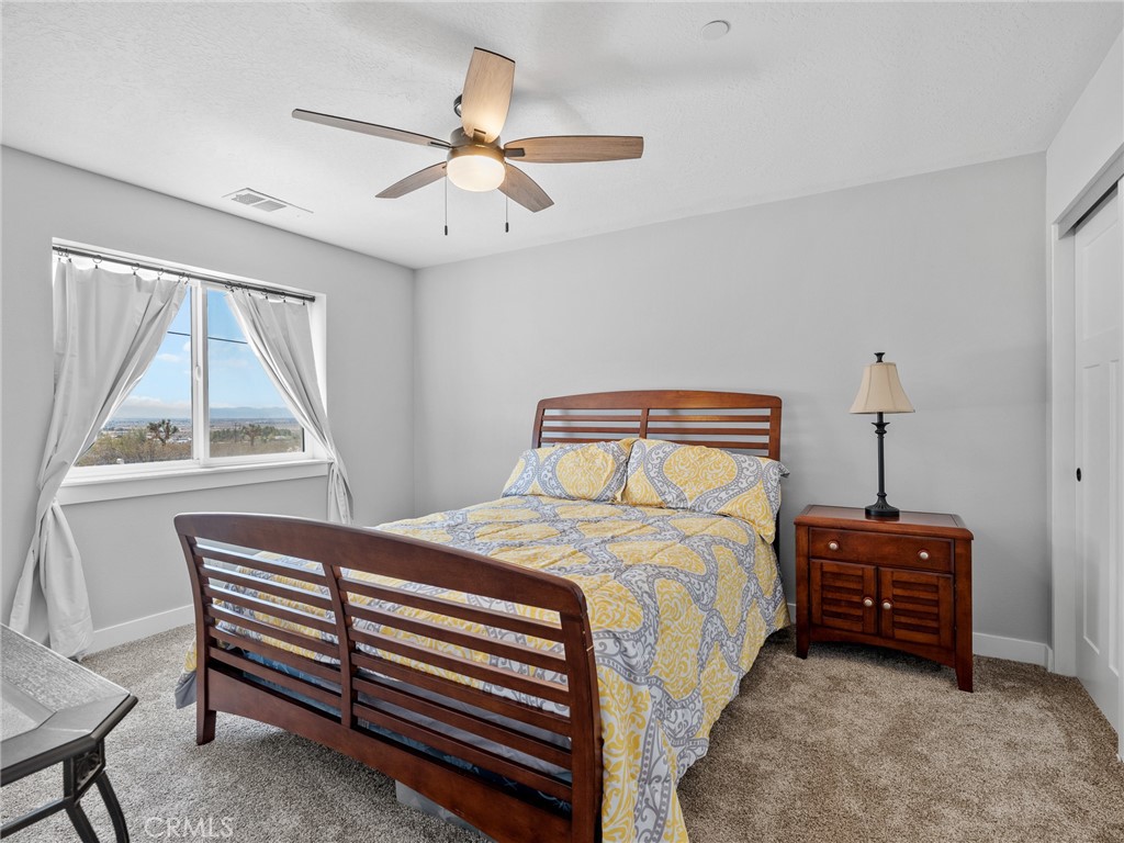 24162 Shoshone Road Apple Valley, CA 92307 - Photo 19 of 40 a bedroom with a bed a dresser and a window