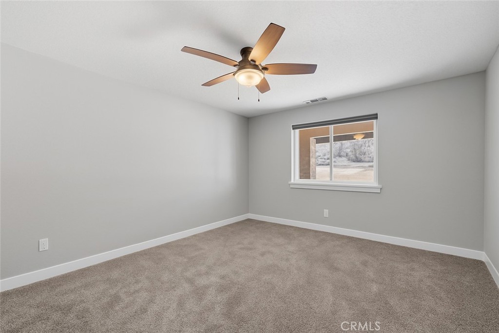 24162 Shoshone Road Apple Valley, CA 92307 - Photo 21 of 40 an empty room with window and ceiling fan