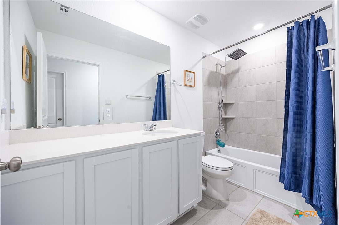 1909 Four Waters Loop Georgetown, TX 78628 - Photo 24 of 35 a bathroom with a double vanity sink toilet mirror and shower