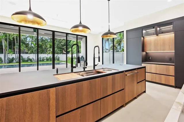 a large kitchen with kitchen island a large window and a sink