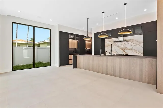 a large white kitchen with a large window