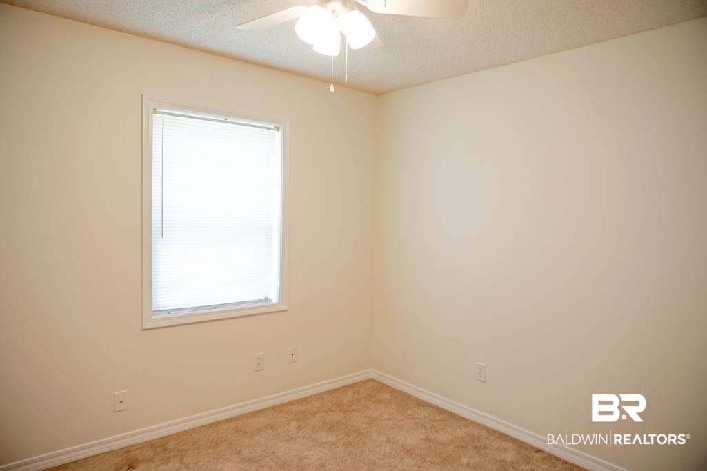 4377 Fathbrook Lane Mobile, AL 36693 - Photo 14 of 19 Spare room featuring light colored carpet, ceiling fan, baseboards, and a textured ceiling