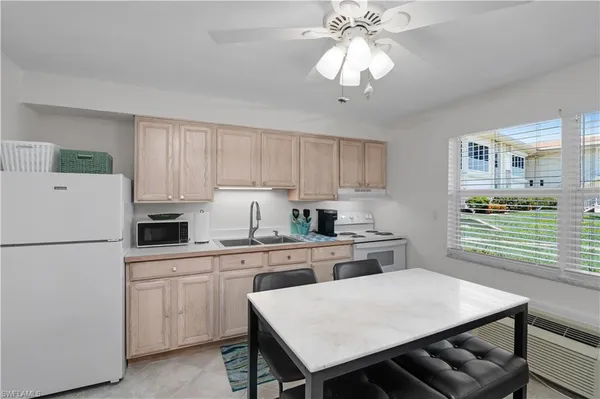 a kitchen with cabinets appliances and wooden floor