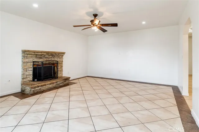 a view of an empty room and chandelier fan