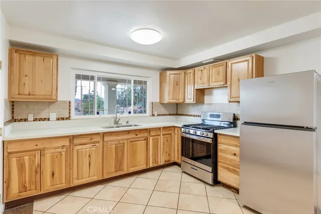 a kitchen with granite countertop white cabinets white appliances a sink and a window