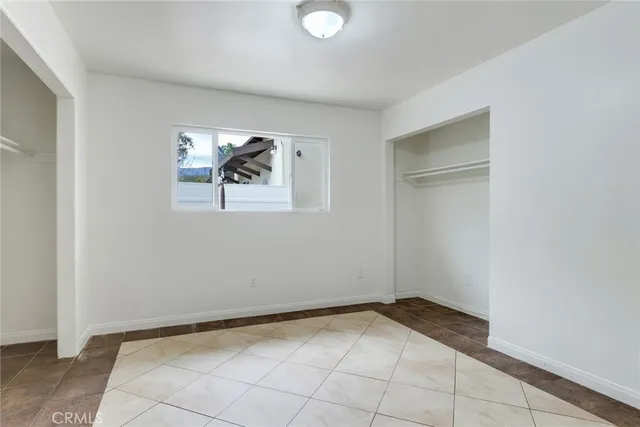 an empty room with floor to ceiling window and an outdoor view