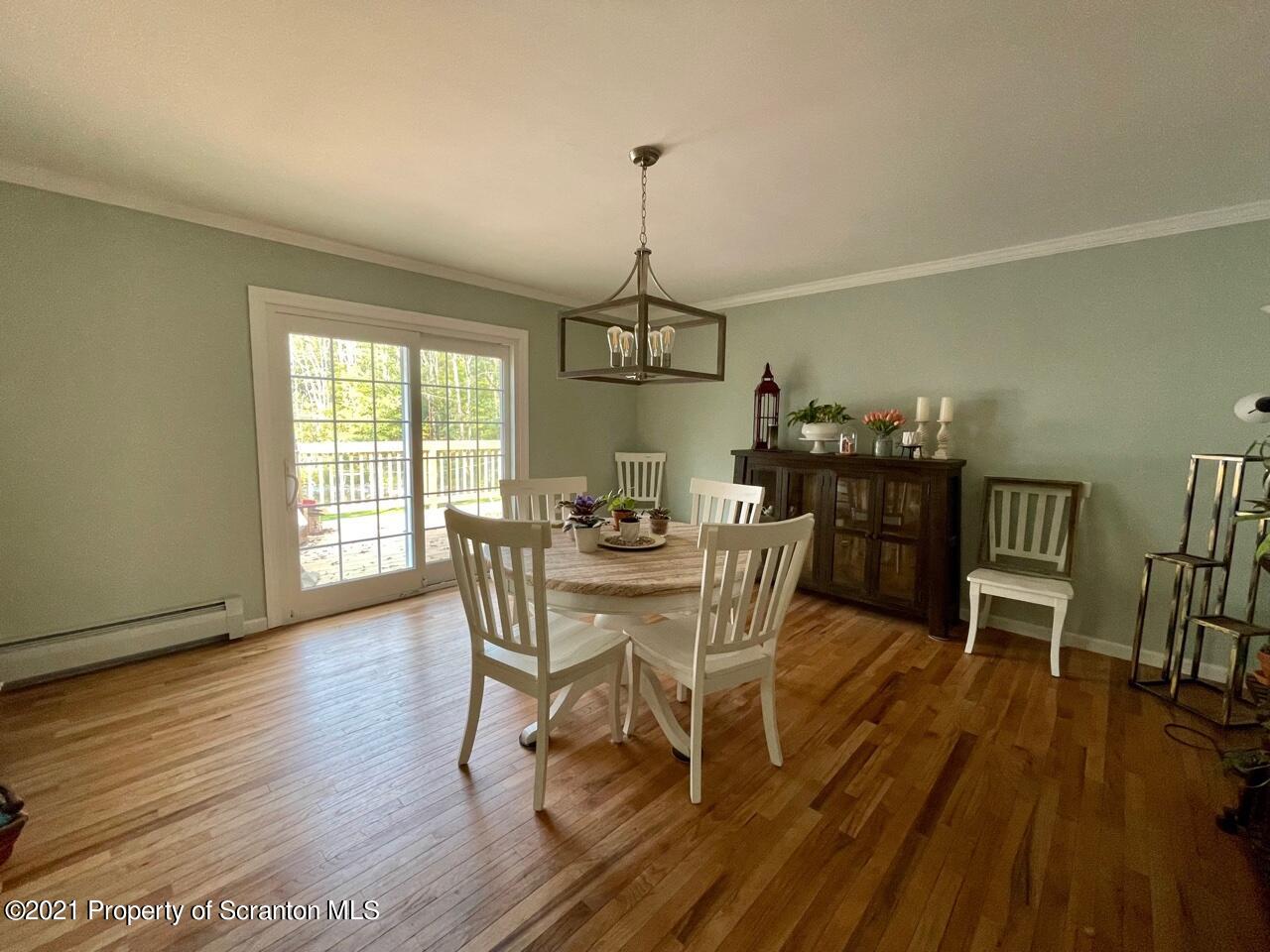 129 State Rte 2023 Forest City, PA 18421 - Photo 6 of 17 a dining room with wooden floor a chandelier a wooden table and chairs