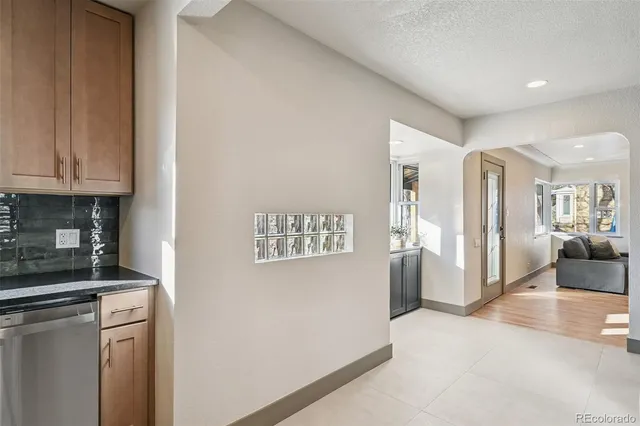 a kitchen with stainless steel appliances kitchen island granite countertop a table chairs sink and cabinets