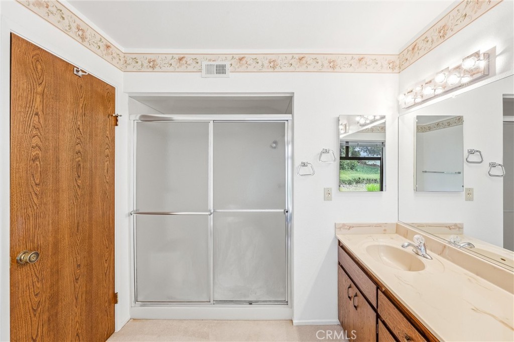 37295 Oak View Road Yucaipa, CA 92399 - Photo 35 of 59 a bathroom with a sink a mirror and a shower