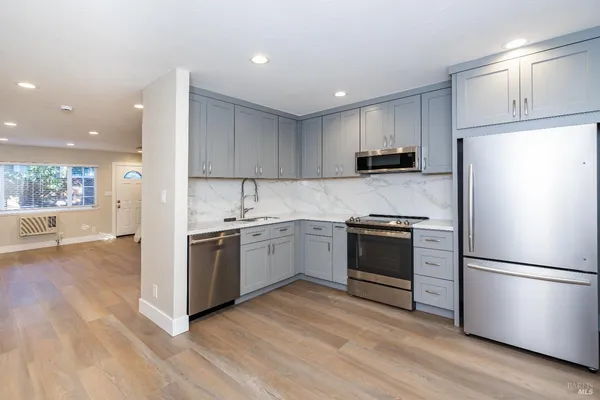 a kitchen with a refrigerator and a stove top oven