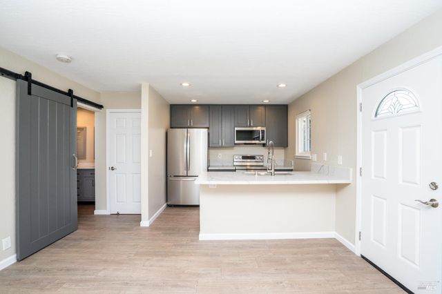 a view of kitchen with stainless steel appliances cabinets