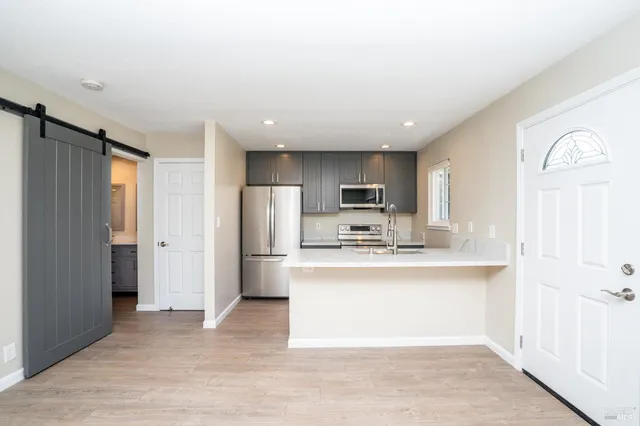 a view of kitchen with stainless steel appliances cabinets